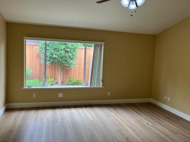 2157 West Rue St Michel Fresno, CA 93711 - Photo 10 of 22 an empty room with wooden floor and windows