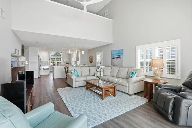 a living room with furniture wooden floor and a large window