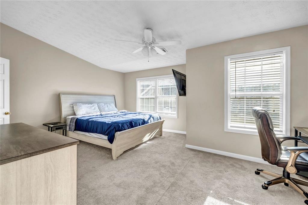 1246 Adcox Square Stone Mountain, GA 30088 - Photo 13 of 22 a spacious bedroom with a bed a table and chair