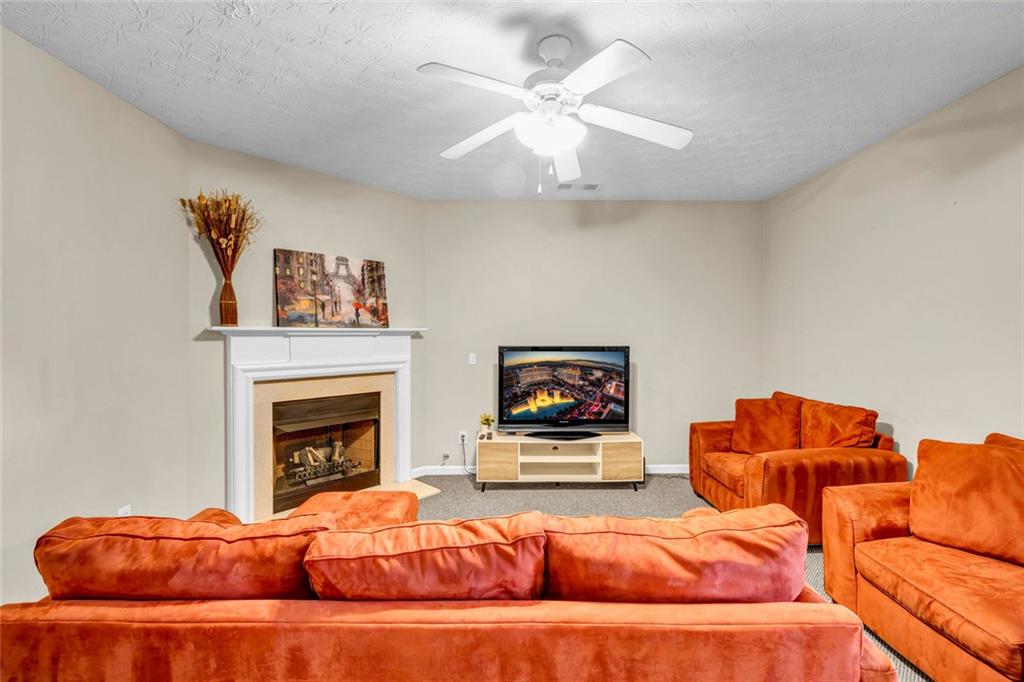 1246 Adcox Square Stone Mountain, GA 30088 - Photo 9 of 22 a living room with furniture a fireplace and a flat screen tv