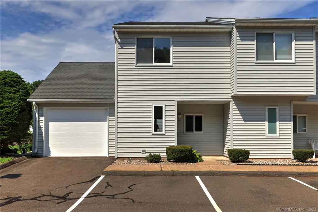 155 Redstone Hill Road, Unit 91 Bristol, CT 06010 - Photo 1 of 1 a side view of a house with a yard and garage