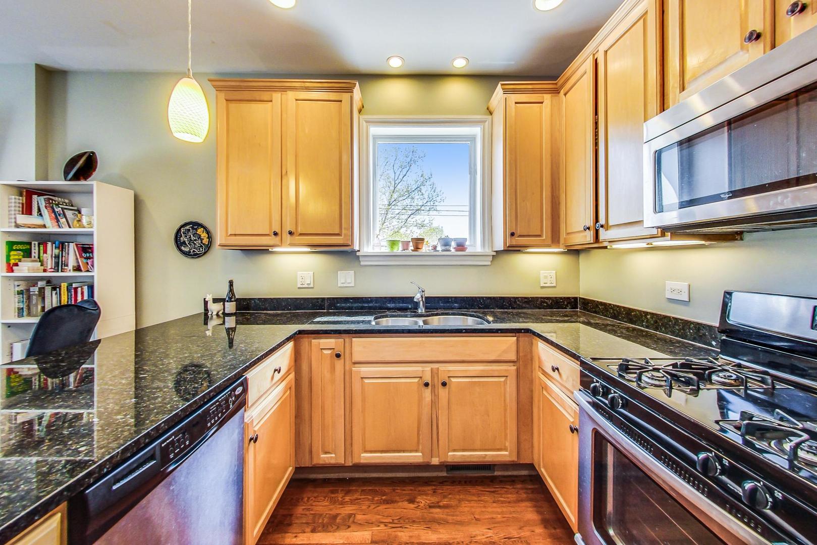 1033 West Taylor Street, Unit 2E Chicago, IL 60607 - Photo 7 of 20 a kitchen with stainless steel appliances granite countertop a sink a stove and a wooden cabinets