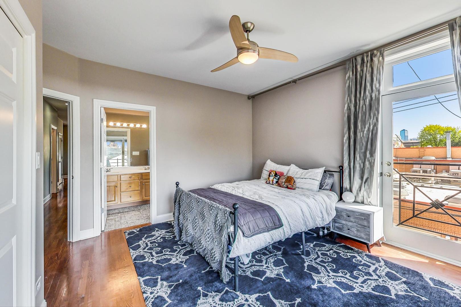 1033 West Taylor Street, Unit 2E Chicago, IL 60607 - Photo 10 of 20 a bedroom with a large bed and a chandelier