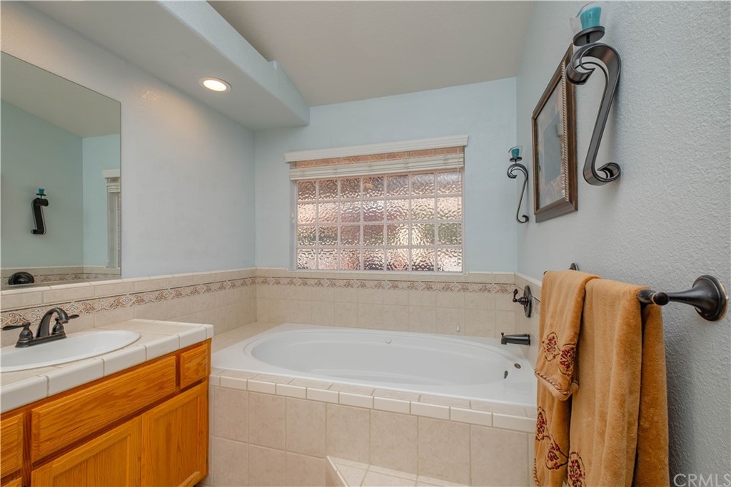 16196 Ridge View Drive Apple Valley, CA 92307 - Photo 40 of 68 a bathroom with a tub sink and mirror