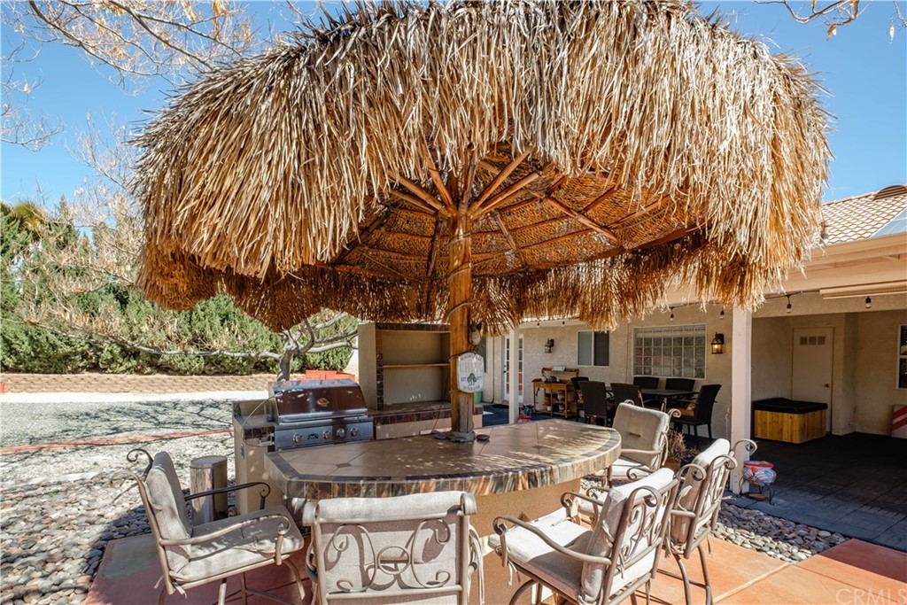 16196 Ridge View Drive Apple Valley, CA 92307 - Photo 50 of 68 a view of a patio with table and chairs and potted plants