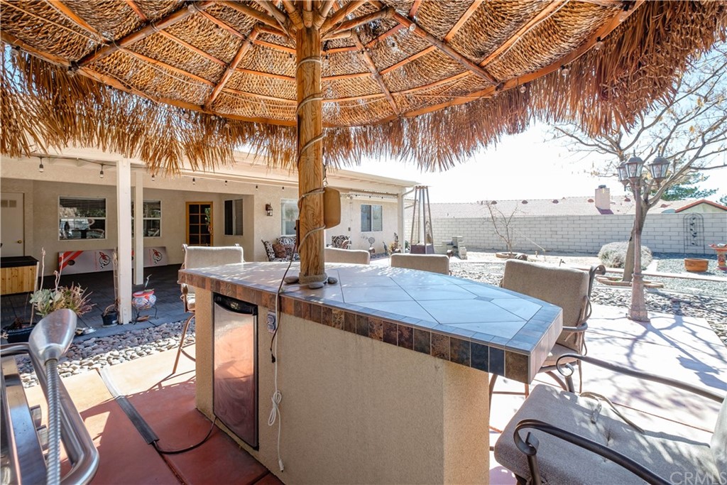 16196 Ridge View Drive Apple Valley, CA 92307 - Photo 53 of 68 a view of a patio with couches table and chairs under an umbrella