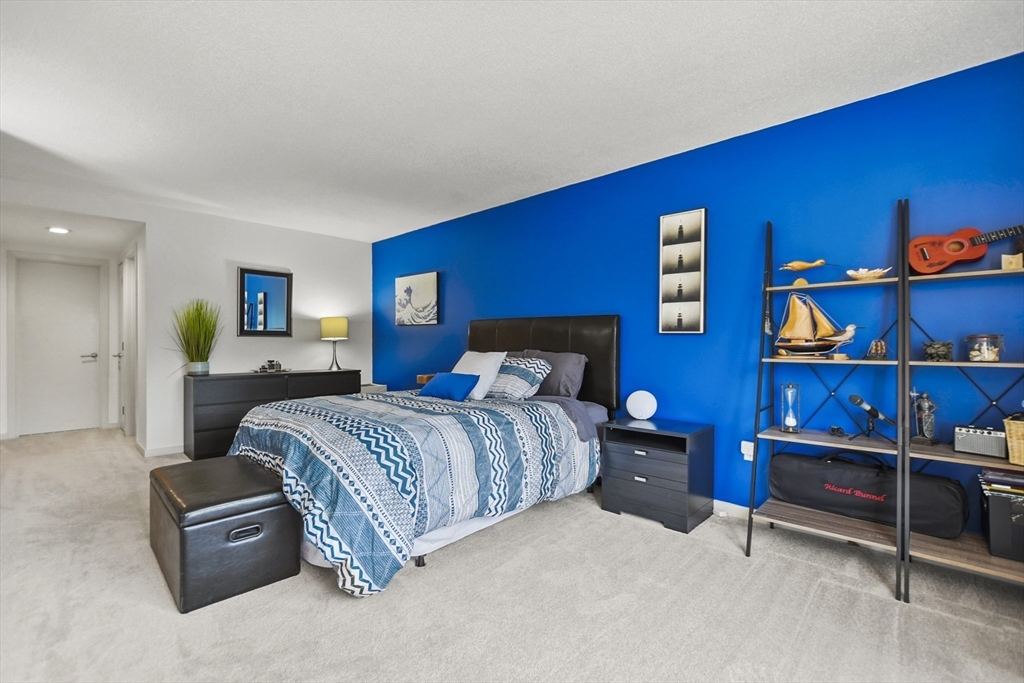 431 Place Lane, Unit 431 Woburn, MA 01801 - Photo 25 of 38 a spacious bedroom with a bed and a bookshelf