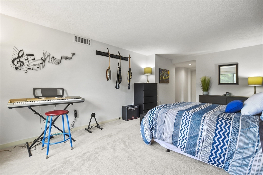 431 Place Lane, Unit 431 Woburn, MA 01801 - Photo 26 of 38 a bedroom with a bed and chair