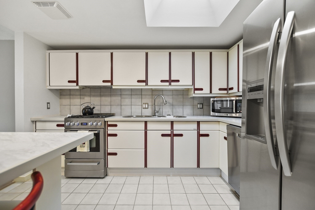 431 Place Lane, Unit 431 Woburn, MA 01801 - Photo 4 of 38 a kitchen with stainless steel appliances a stove sink and cabinets