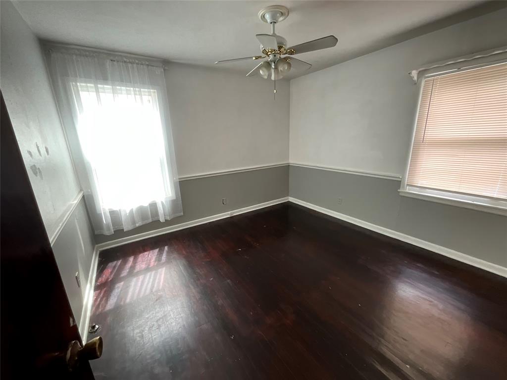 629 Harrison Lane Hurst, TX 76053 - Photo 7 of 20 an empty room with wooden floor fan and windows