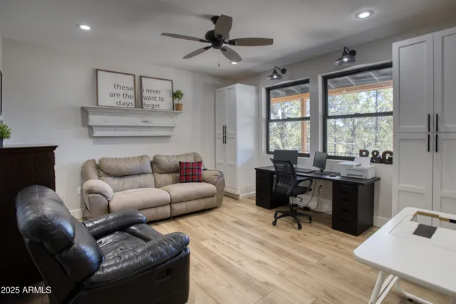 a view of a livingroom with furniture wooden floor windows and a chandelier
