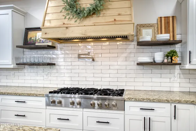 a kitchen with stainless steel appliances granite countertop a table chairs sink refrigerator and microwave