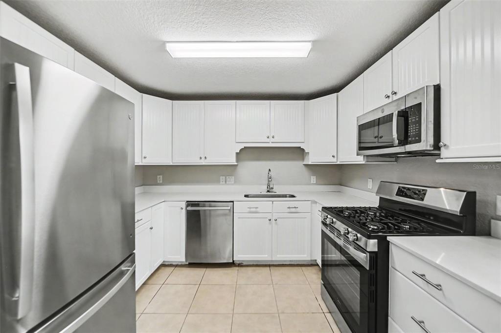 1109 Inland Street Leesburg, FL 34748 - Photo 5 of 15 a kitchen with stainless steel appliances granite countertop a stove a sink and a microwave