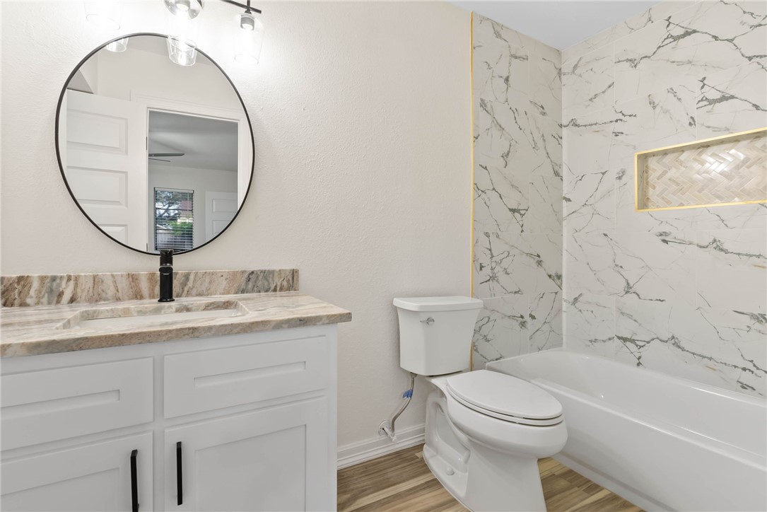 1906 Oak Ridge Drive Portland, TX 78374 - Photo 15 of 20 a bathroom with a granite countertop toilet a sink and a mirror