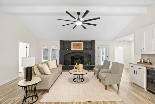 a living room with furniture a fireplace and a chandelier