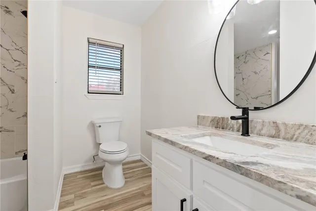 a bathroom with a toilet sink and mirror