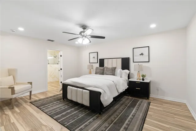 a bedroom with a large bed and a chandelier