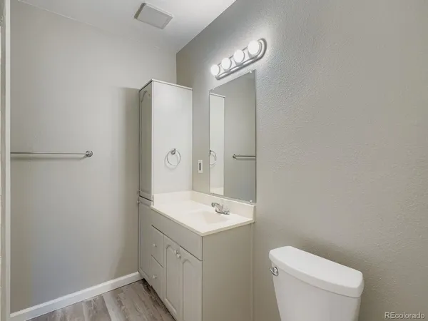 a bathroom with a toilet a sink a mirror and vanity