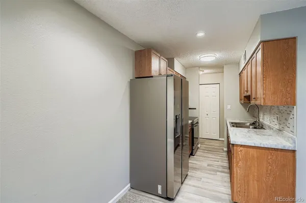 a kitchen with a sink a refrigerator and cabinets
