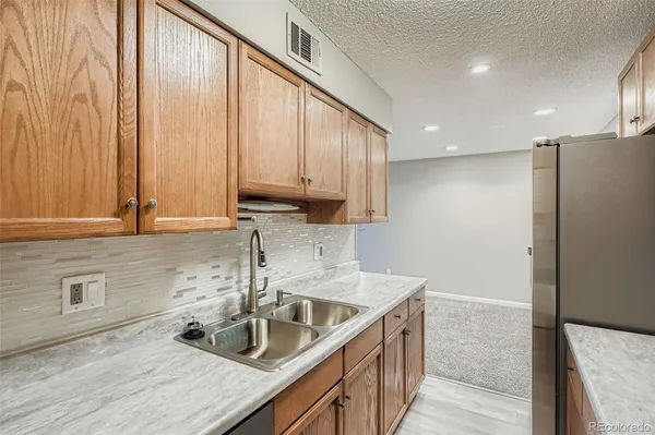 a kitchen with stainless steel appliances granite countertop a refrigerator and a sink