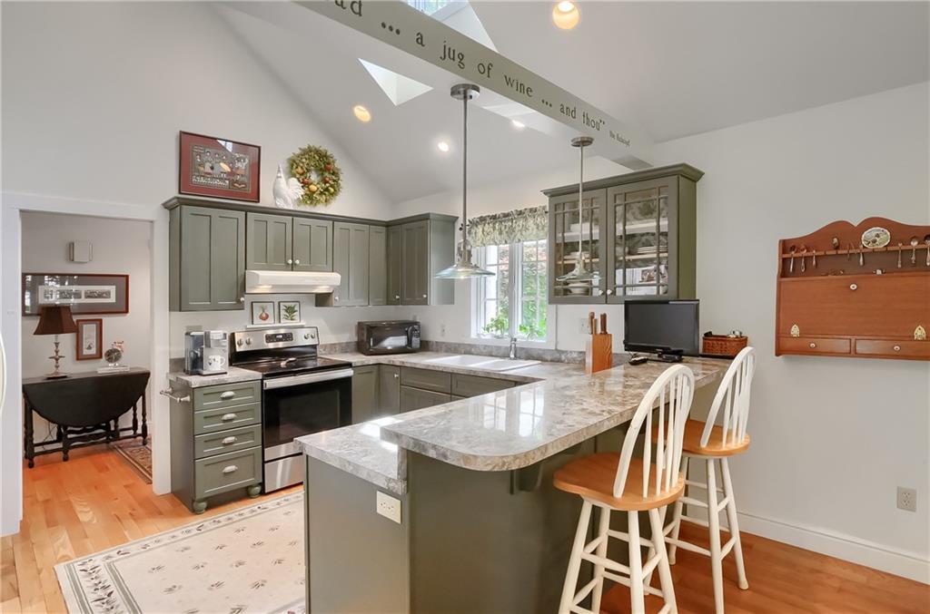 206 Reiber Road Renfrew, PA 16053 - Photo 19 of 43 a kitchen with stainless steel appliances granite countertop a stove top oven a sink a dining table and chairs with wooden floor