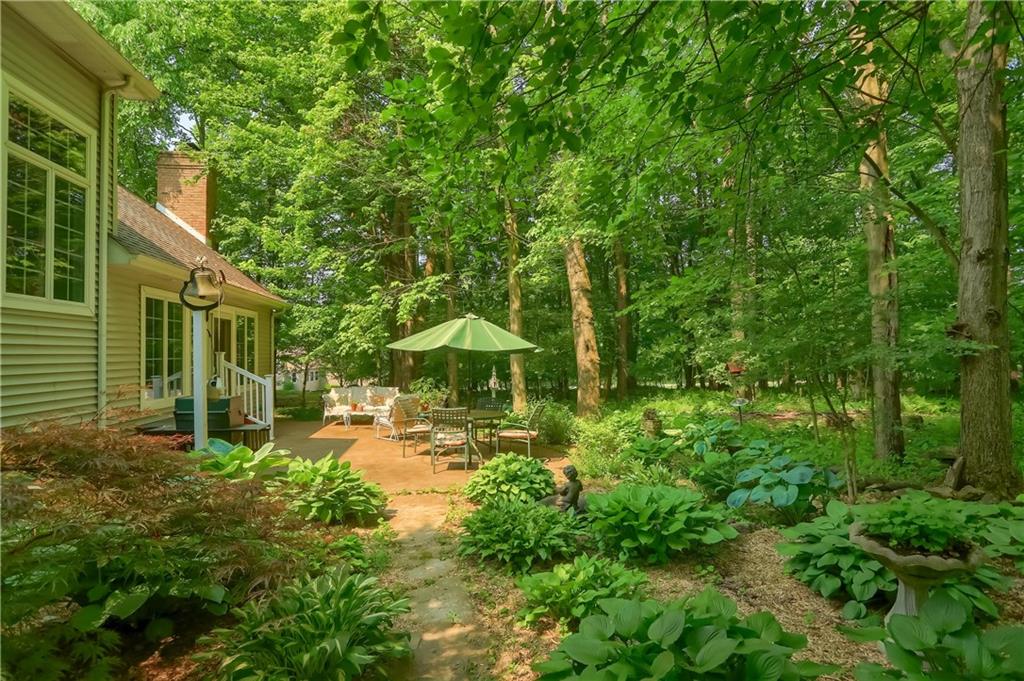 206 Reiber Road Renfrew, PA 16053 - Photo 39 of 43 a view of a garden with a bench under an umbrella