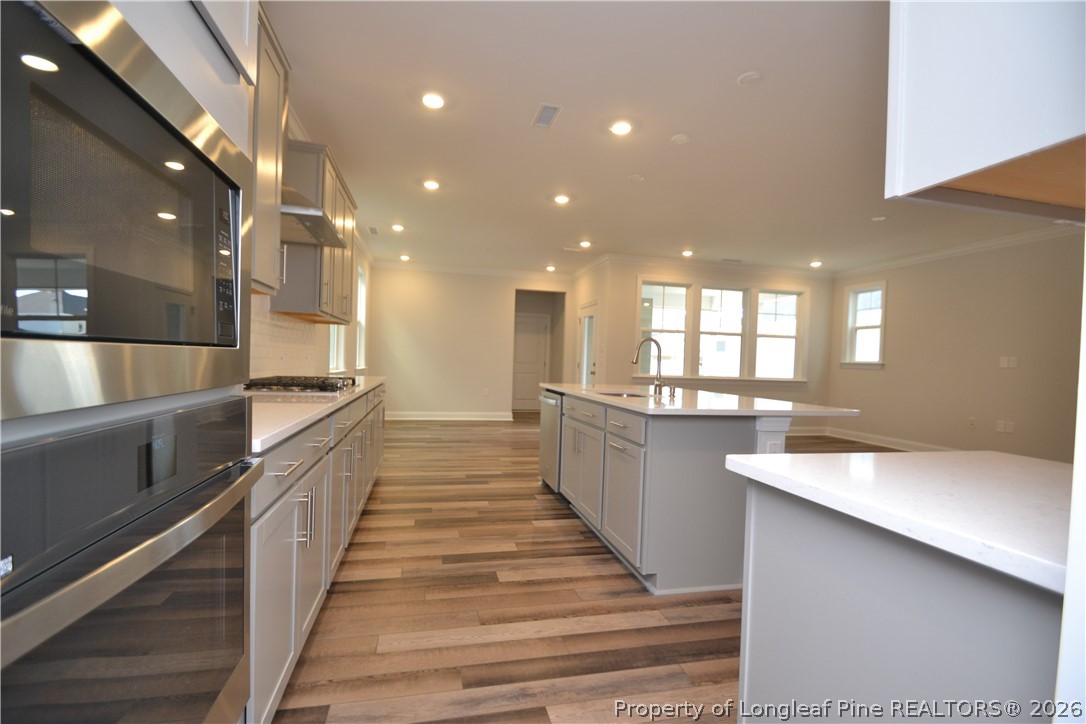421 Canyon Spring Trail Wake Forest, NC 27587 - Photo 12 of 50 a large white kitchen with a large counter top appliances and cabinets