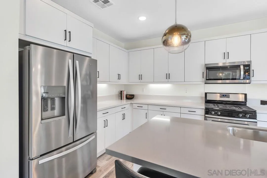 8844 Weston Road Santee, CA 92071 - Photo 12 of 48 a kitchen with stainless steel appliances a refrigerator a stove a sink and a center island