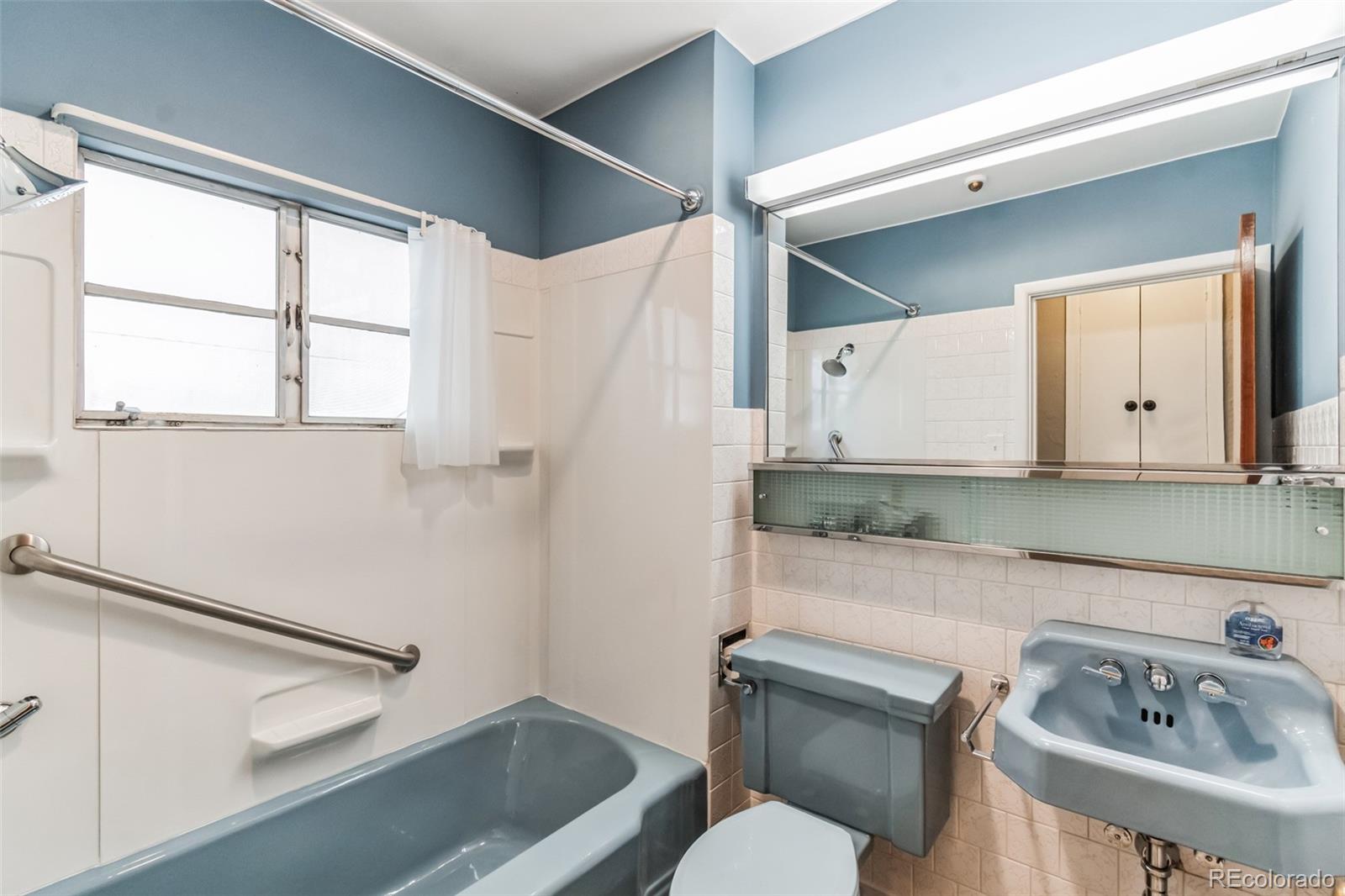 2435 South Race Street Denver, CO 80210 - Photo 12 of 33 a bathroom with a sink a toilet and a mirror