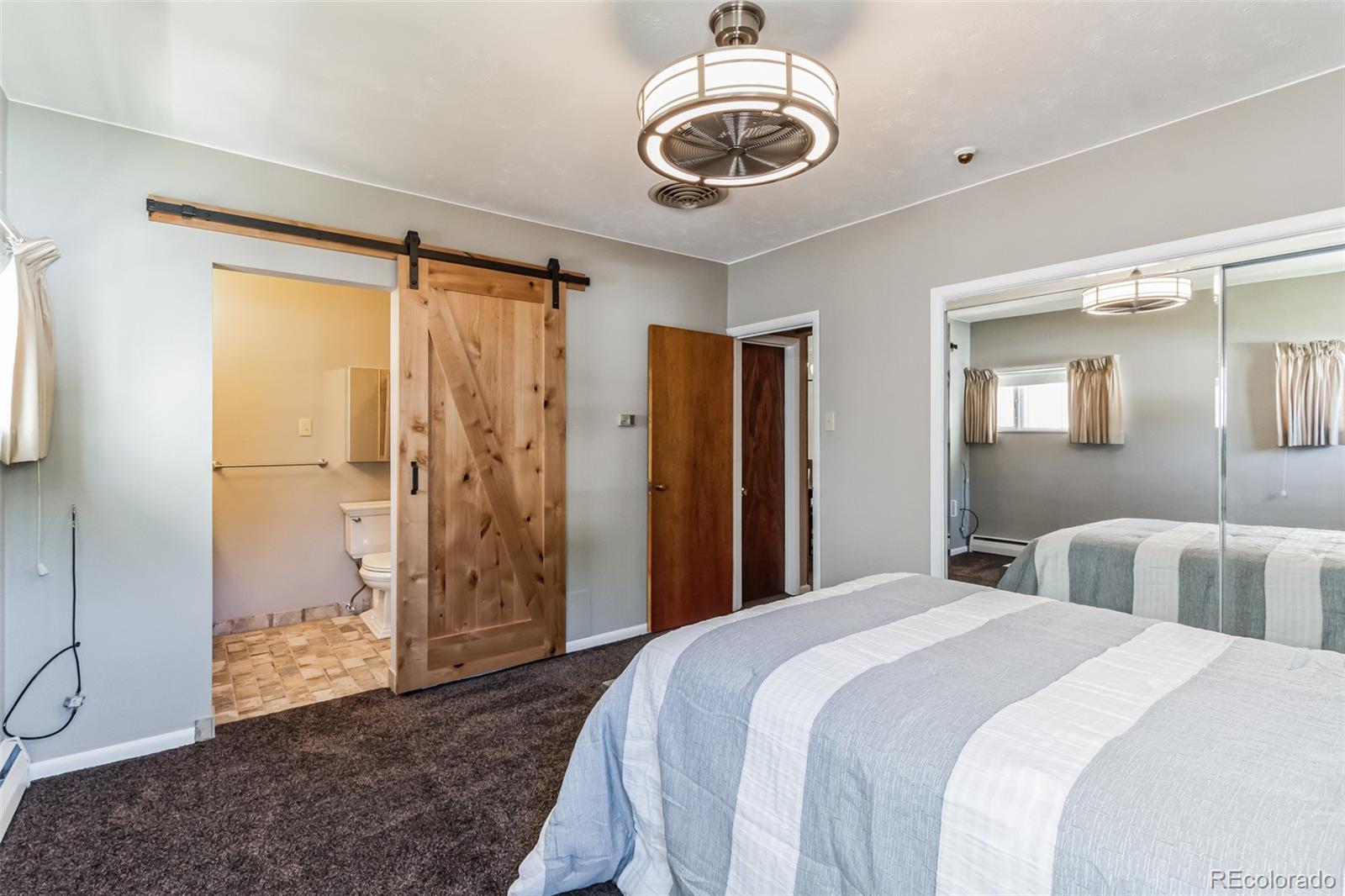 2435 South Race Street Denver, CO 80210 - Photo 15 of 33 a bedroom with a large bed and a chandelier