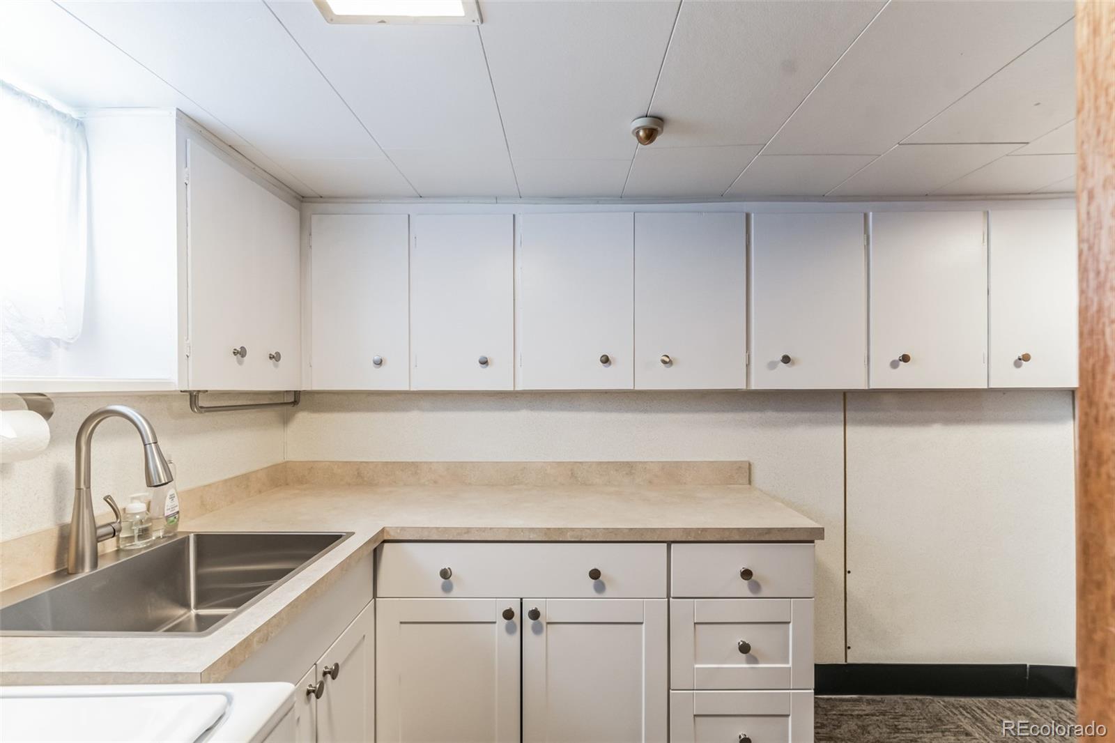 2435 South Race Street Denver, CO 80210 - Photo 22 of 33 a kitchen with granite countertop white cabinets and sink