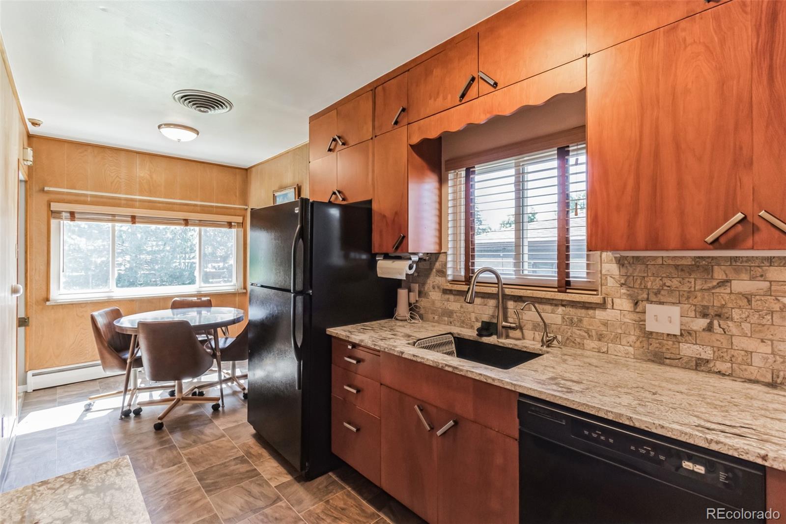 2435 South Race Street Denver, CO 80210 - Photo 8 of 33 a kitchen with a refrigerator a sink dishwasher a stove and a dining table with wooden cabinet