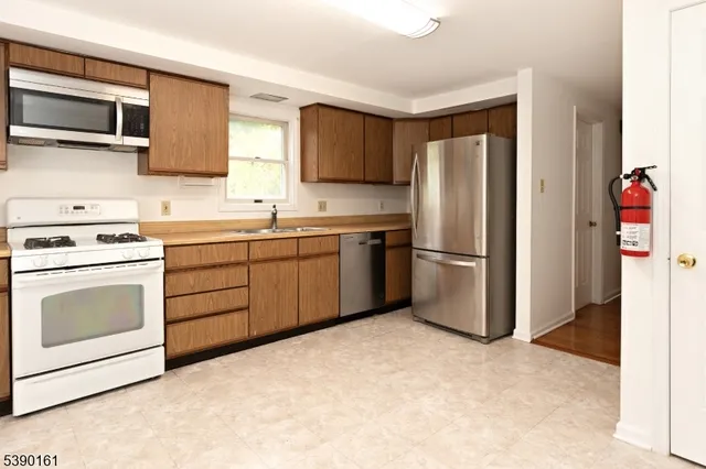 a kitchen with stainless steel appliances granite countertop a refrigerator stove a sink and dishwasher