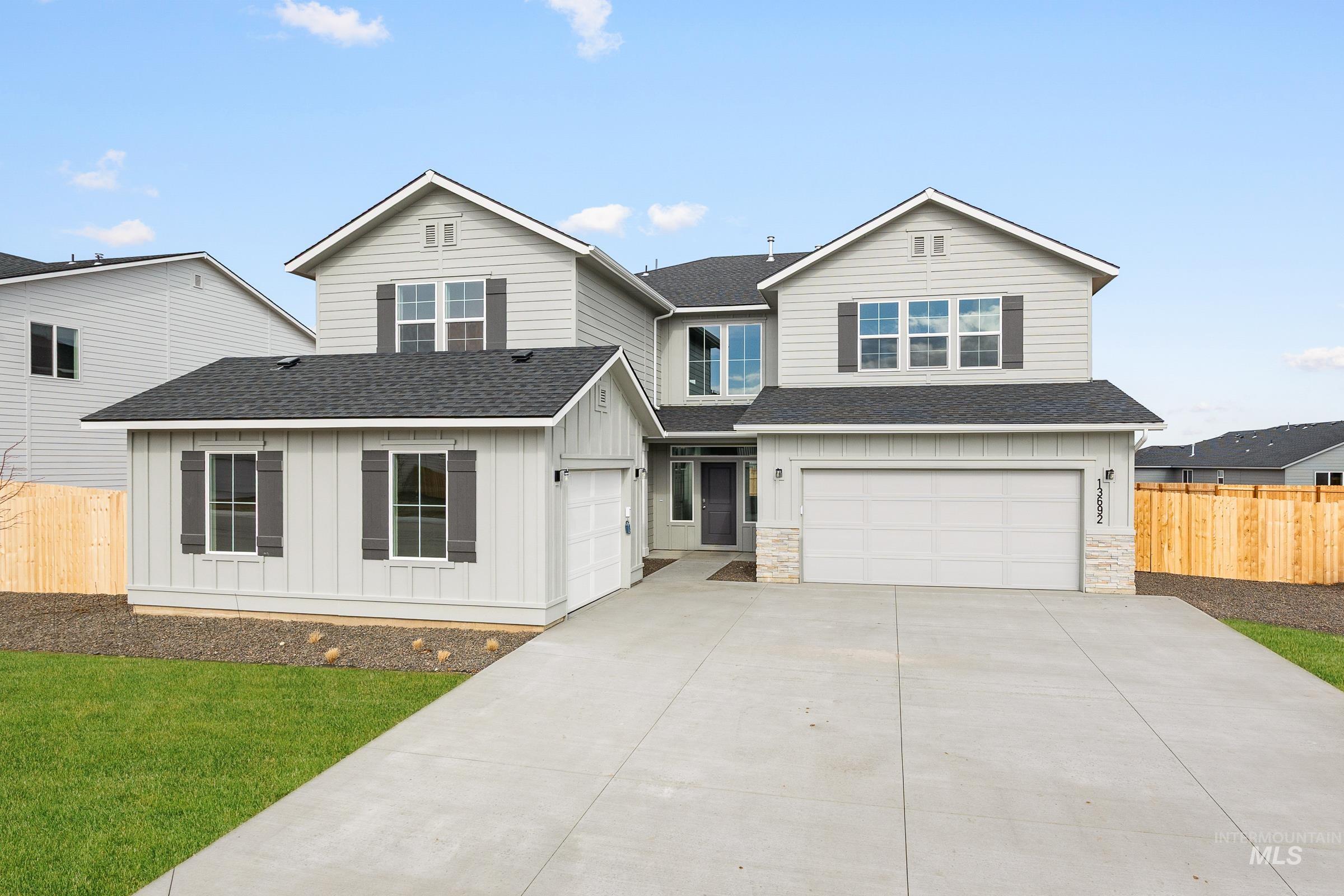 View of front of property featuring roof with shingles, board and batten siding, a garage, and concrete driveway