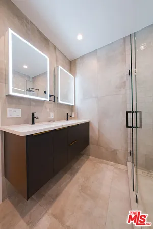 a bathroom with a sink a large mirror and a shower