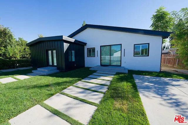 a balcony with table and chairs and potted plants