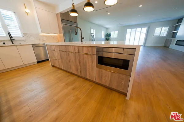 a kitchen with stainless steel appliances granite countertop a sink a stove and a refrigerator