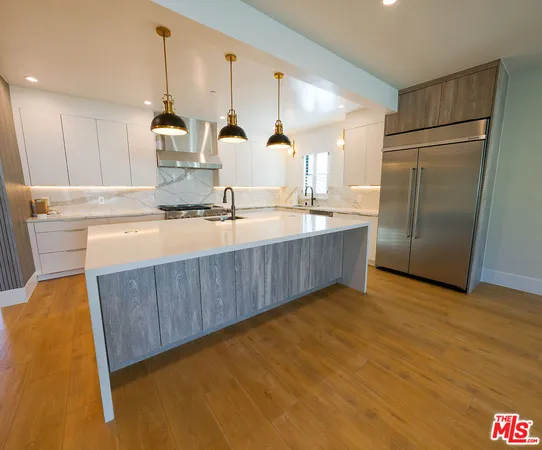a kitchen with stainless steel appliances a sink a refrigerator and a stove