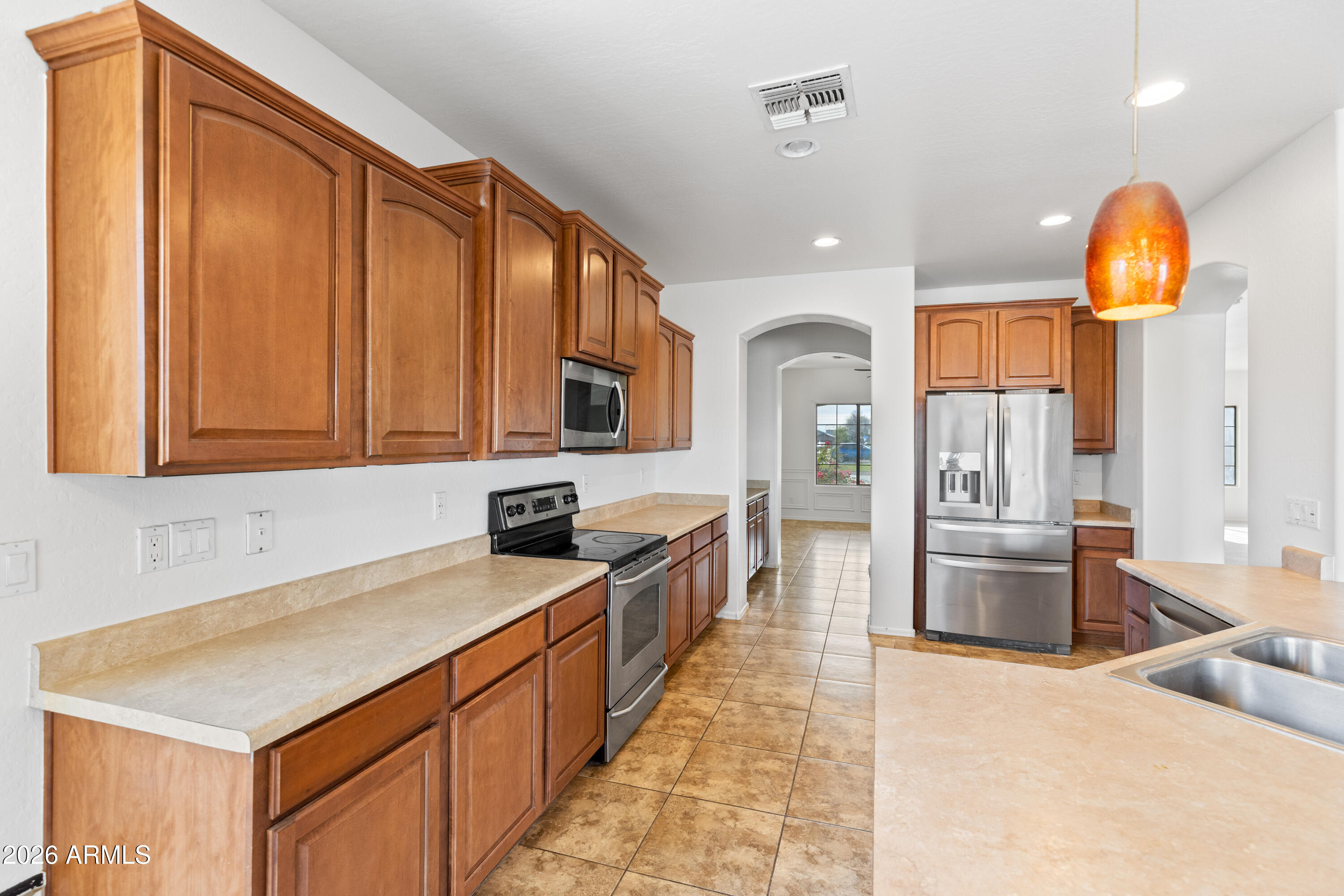9840 Tangerine Road Florence, AZ 85132 - Photo 16 of 38 a kitchen with stainless steel appliances granite countertop a sink a stove and a refrigerator