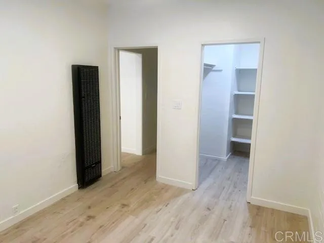 an empty room with wooden floor and closet