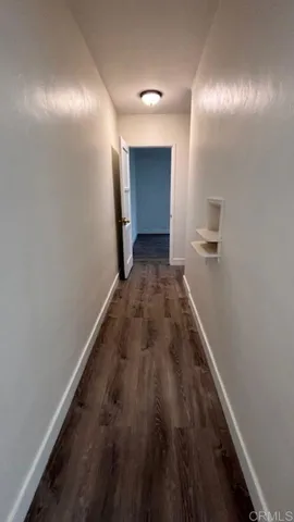 a view of a hallway with wooden floor