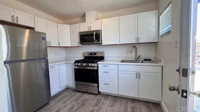 a kitchen with stainless steel appliances a refrigerator sink and microwave