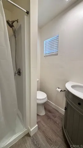 a bathroom with a granite countertop toilet a sink and a shower