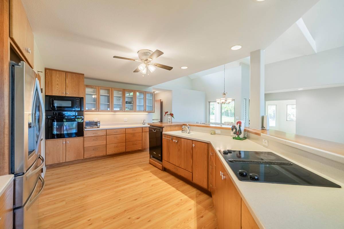370 Akolea Road Hilo, HI 96720 - Photo 12 of 29 a large kitchen with a large counter top space a sink stainless steel appliances and cabinets