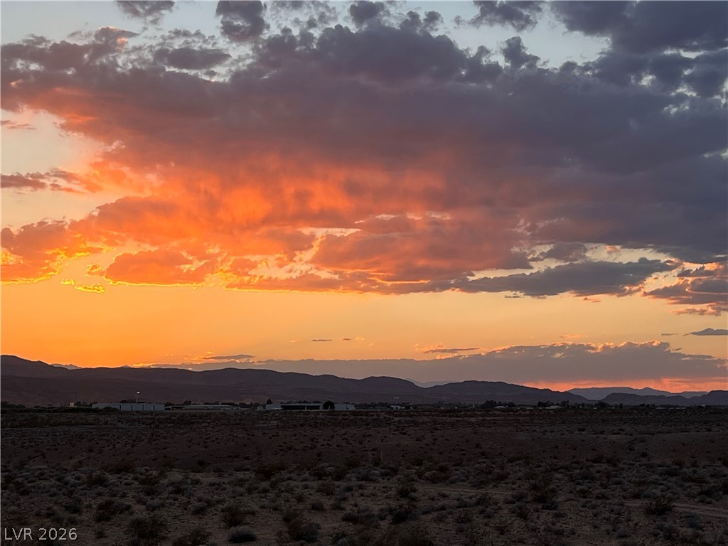 North Ishimoto Overton, NV 89040 - Photo 8 of 10 Witness the dramatic sky above a vast, arid landscape as the sun sets over distant mountains.