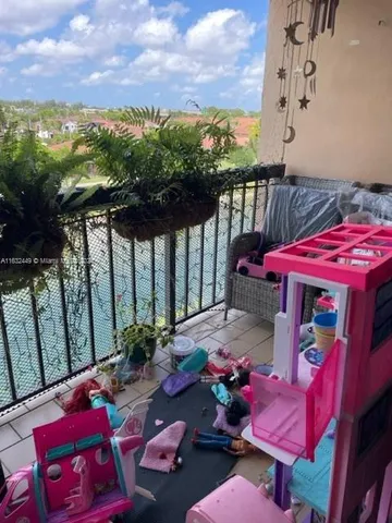 a living room with furniture a flat screen tv and a floor to ceiling window