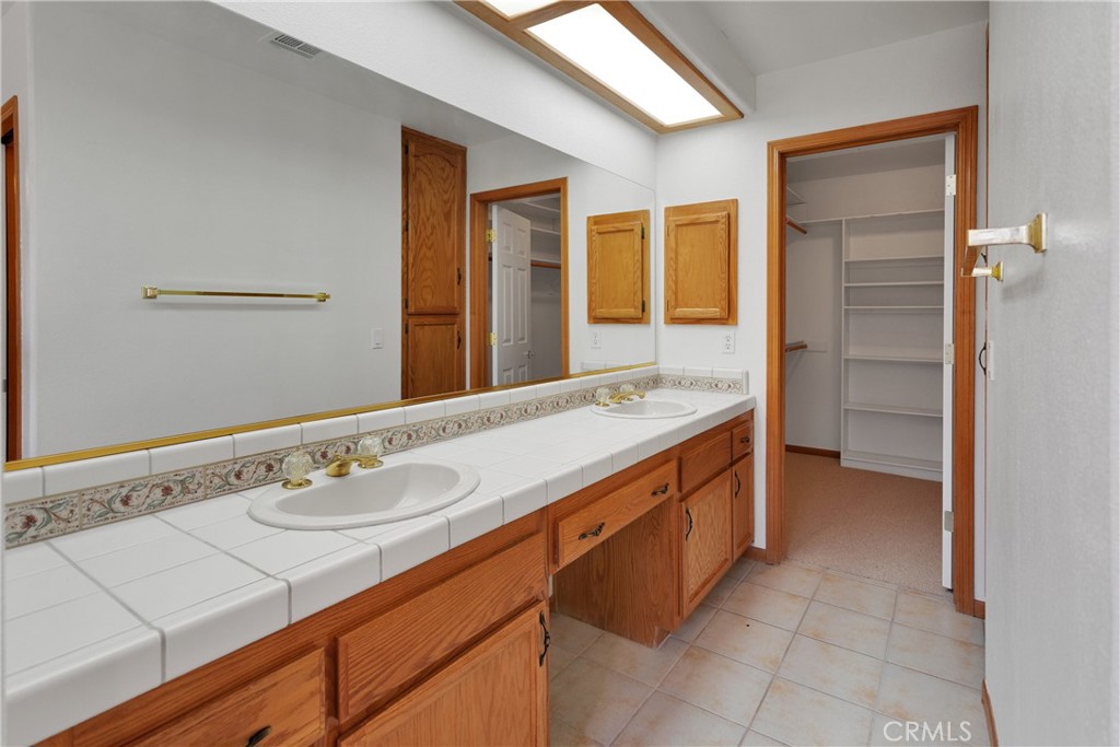 16620 Iwa Road Apple Valley, CA 92307 - Photo 34 of 50 a bathroom with a sink a vanity and a mirror