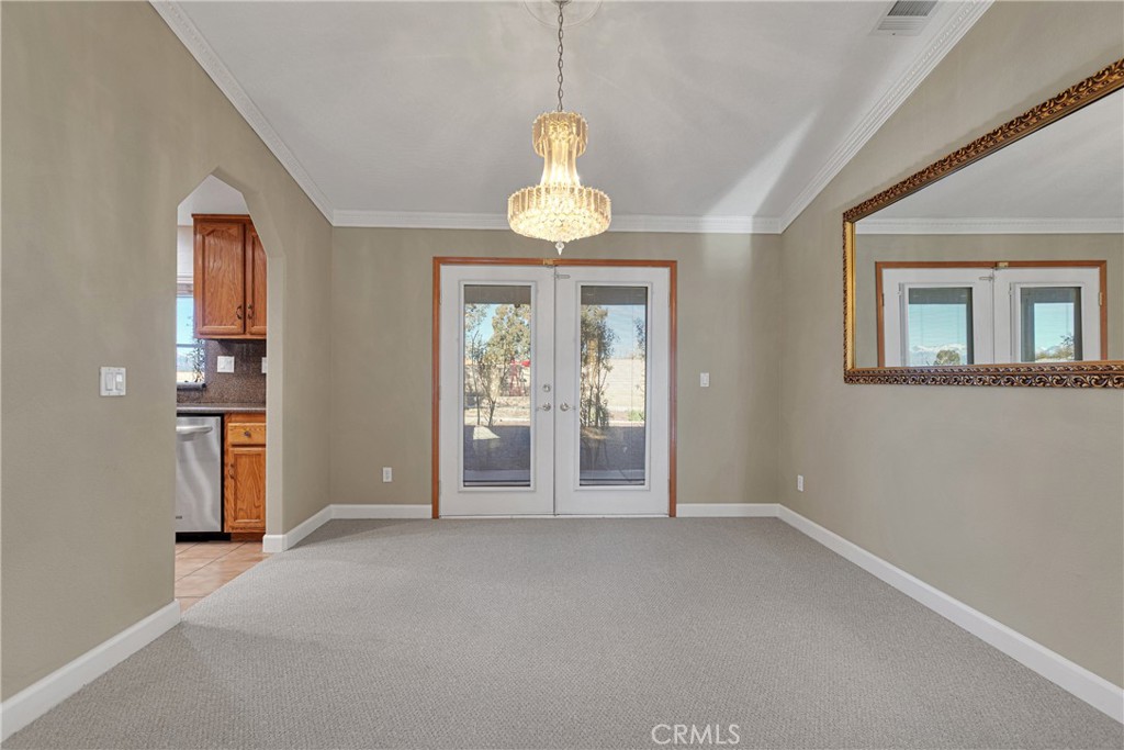 16620 Iwa Road Apple Valley, CA 92307 - Photo 9 of 50 en empty room with windows and chandelier