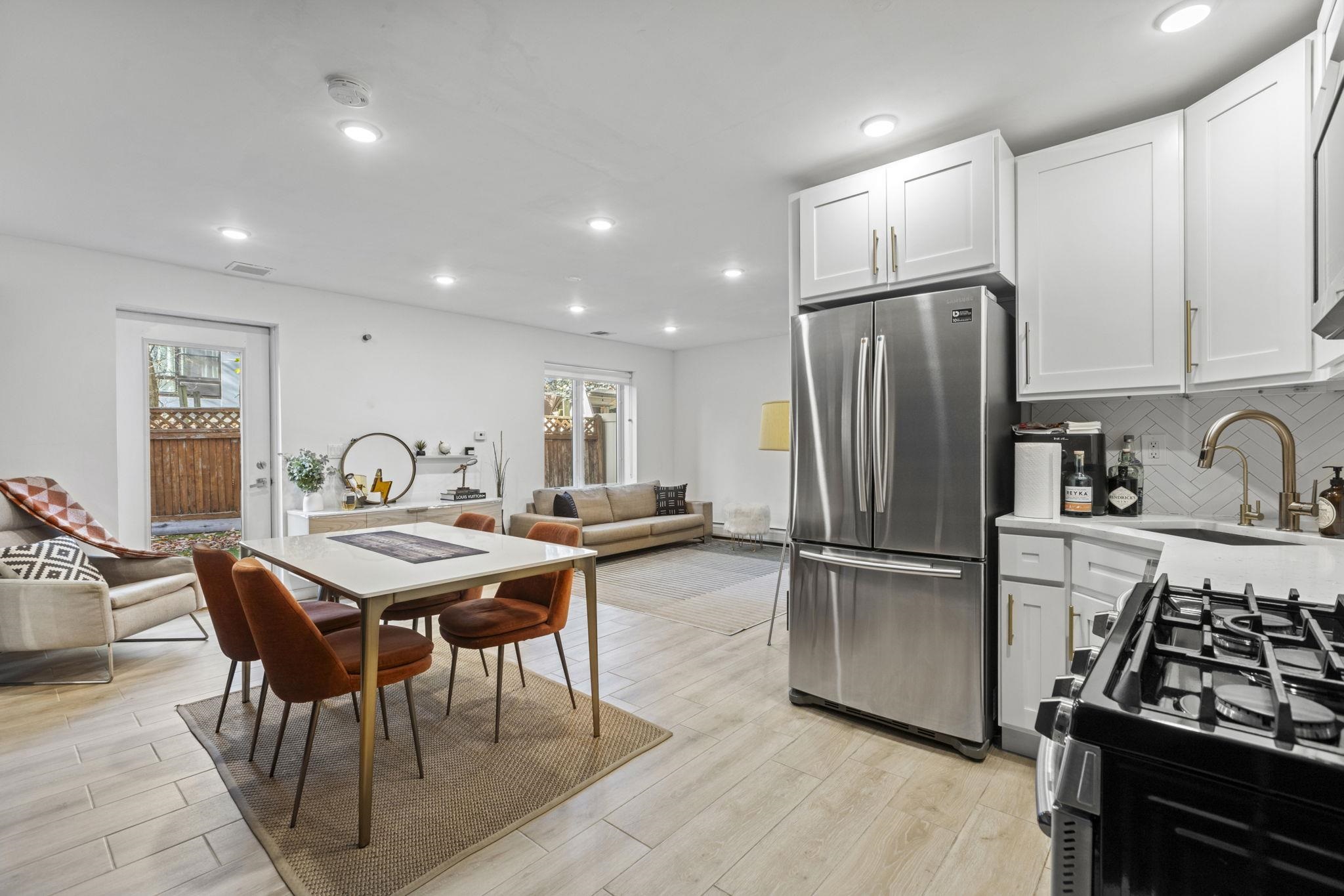 27 Hackensack Plank Road, Unit 1 Weehawken, NJ 07086 - Photo 17 of 23 a kitchen with stainless steel appliances granite countertop a stove refrigerator a table and chairs with wooden floor