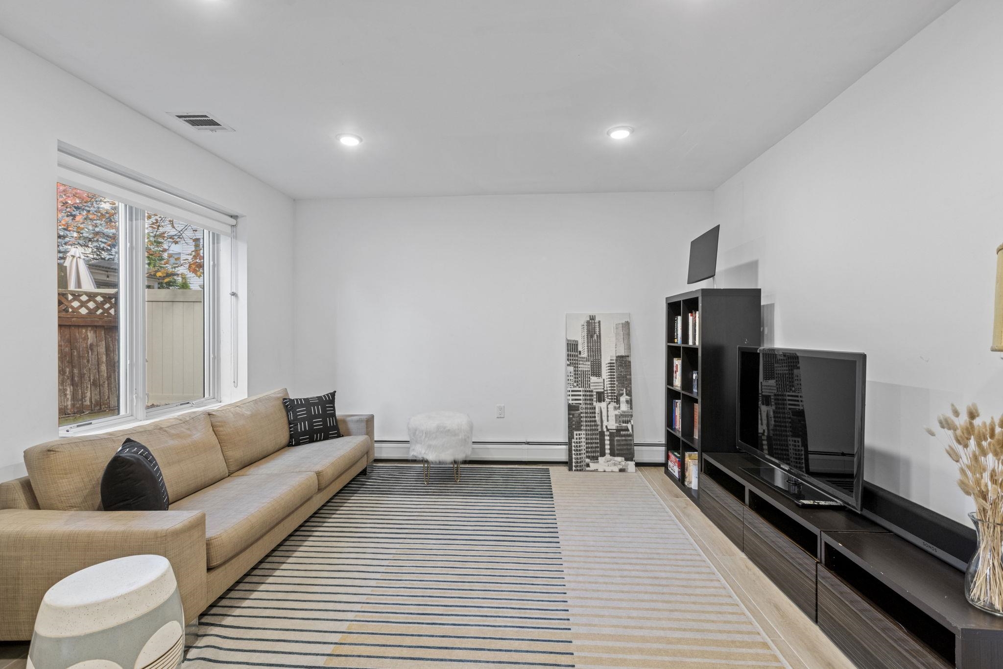 27 Hackensack Plank Road, Unit 1 Weehawken, NJ 07086 - Photo 18 of 23 a living room with furniture and a flat screen tv